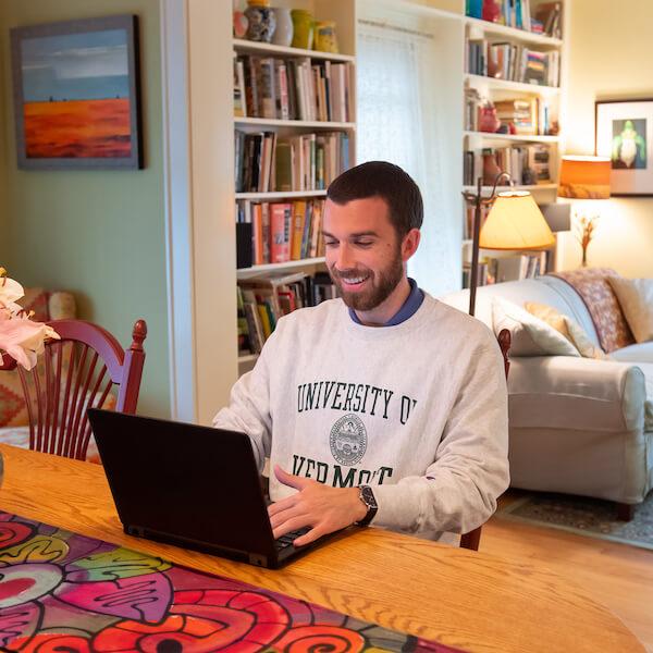 A student works on his laptop at home.
