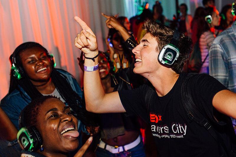 Students wearing headphones dance at a silent disco event