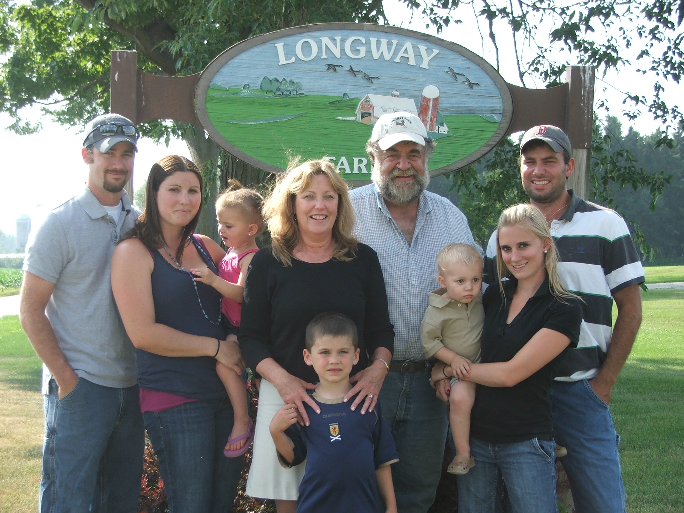 lonway family standing in front of farm sign
