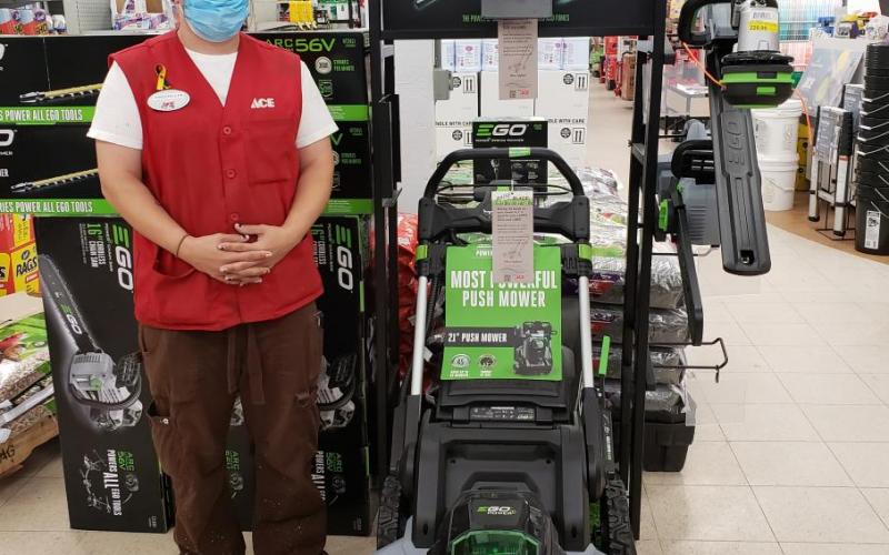 An employee at Bibens Ace Hardware next to the mulching mower. Employee at Bibens Ace Hardware stands next to mulching mower
