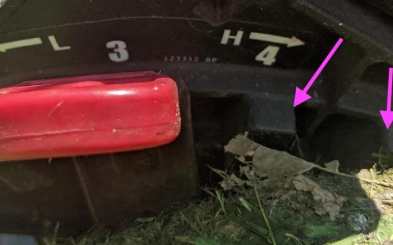 Arrows pointing to teeth on lawn mower blade height adjustment