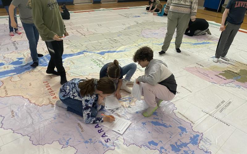 Students explore the giant map while completing an educational scavenger hunt.