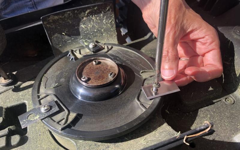 Underside of Mo, the robotic lawnmower, showing 3 blades to unscrew