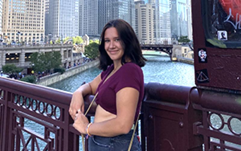 Olivia Szumski on bridge with city backdrop