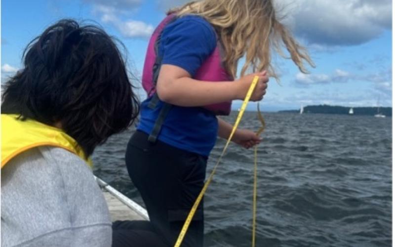 Two campers taking a secchi depth measurement on the dock Two campers taking a secchi depth measurement on the dock