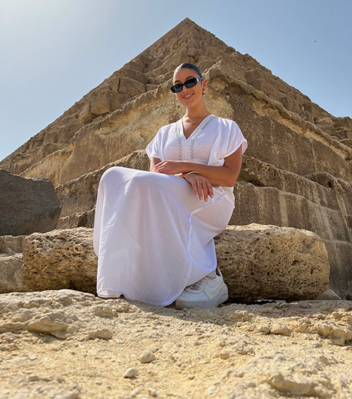 Isabelle seated on the steps of a pyramid in morroco