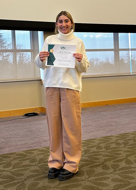 Taylor Bean holding a certificate at the forum