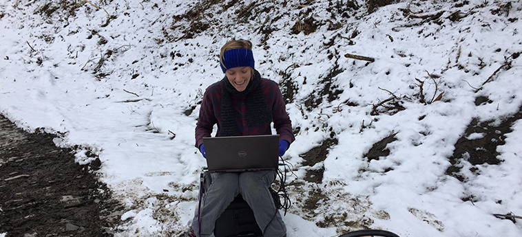 Hannah '18 using her computer out in the snow while collecting data.
