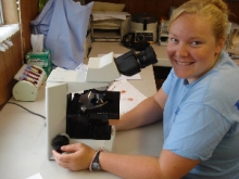 Female student working at a microscope 