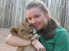 Student hugging lion cub