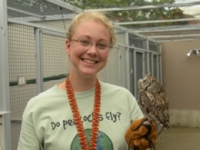 Student with mini owl perched on her hand
