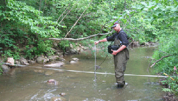 Alex Hackman measuring a stream