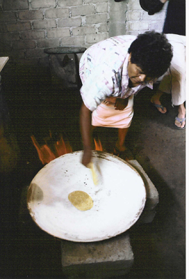 Picture of Woman Making a Tortilla on a Comal