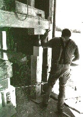 Man jacking up frame of barn.