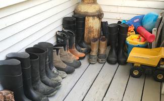 several pairs of boots lined up on a patio