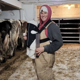 woman with baby in cow barn