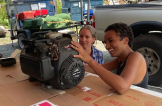 two people working on a small engine