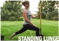 woman doing a standing lunch using a shovel for support