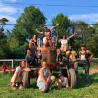 Group photo of farm coworkers posing in front of an antique tractor