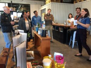 Woman speaks to audience in coffee roastery