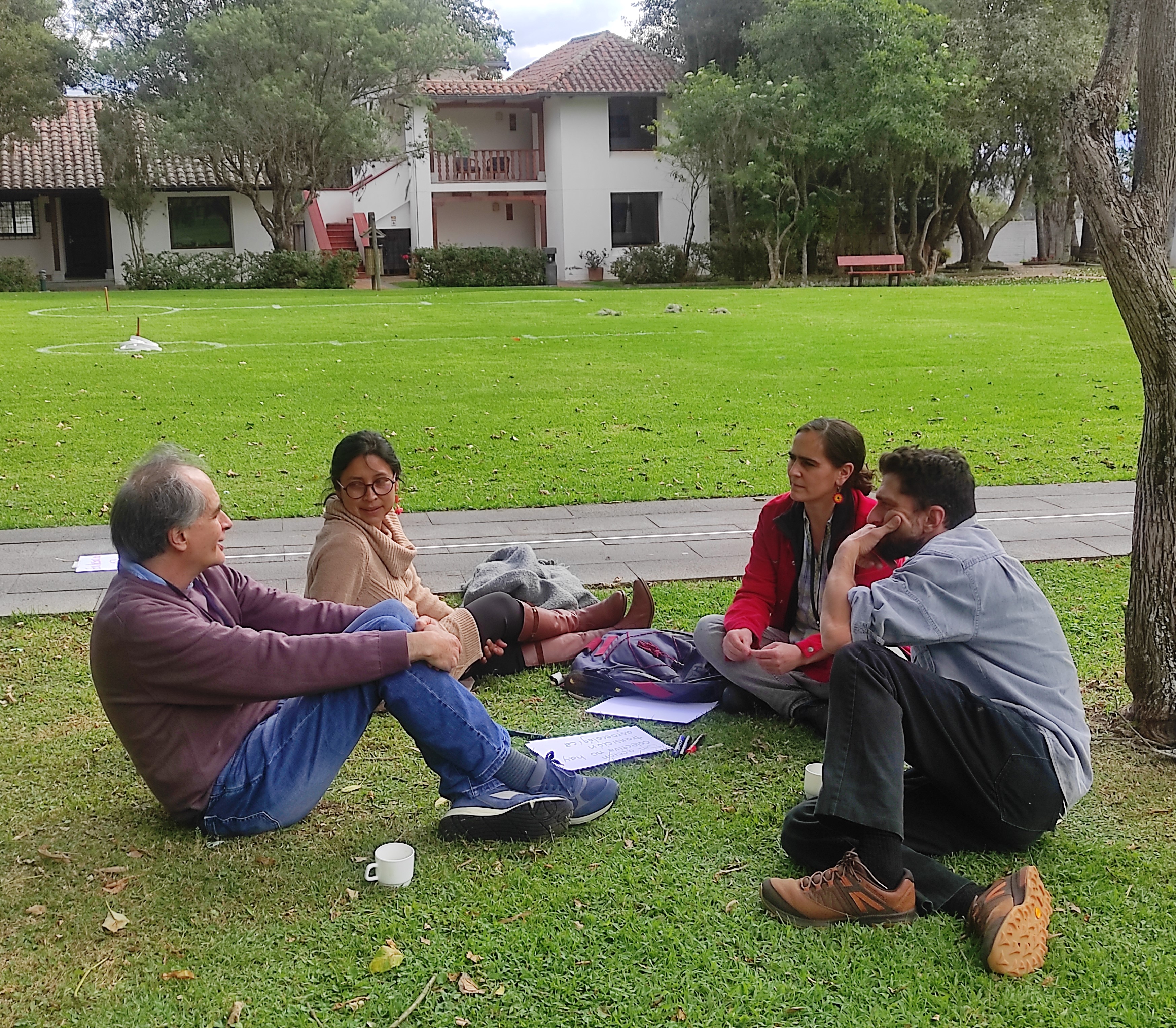 A small group having a discussion seated on the lawn