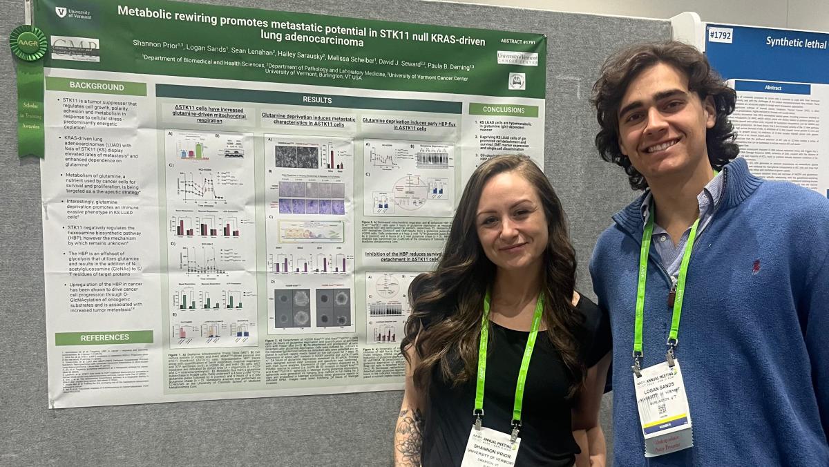 2 people standing in front of their poster at a science conference