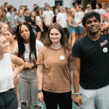 Students stand smiling together