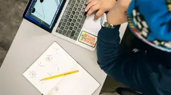 Close up of a laptop computer with a notebook