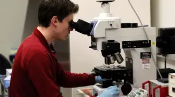 student looking through a microscope