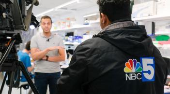 Newscaster speaking to scientist 