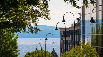 Street lights with Lake Champlain in the background on a sunny day.