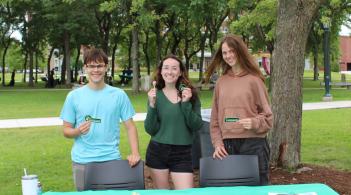 Entrepreneurship Club members pose at their table at the GSB Pizza Resource Fair