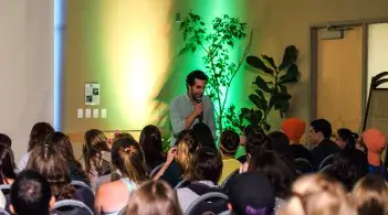 A comedian at the Labor Day Comedy show overlooking a crowd which is laughing back at his jokes