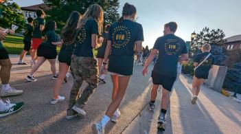 Students walk towards the setting sun during UVM's convocation.