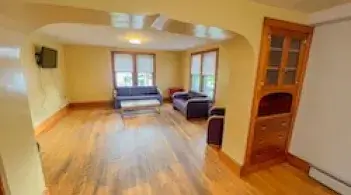 A living room with windows and an open archway. 