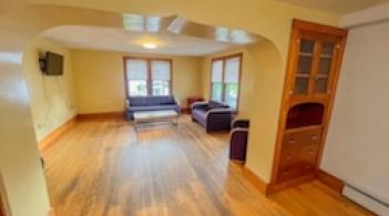 A living room with windows and an open archway. 