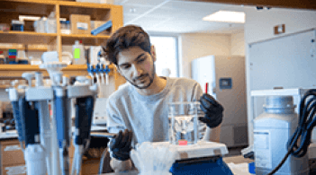 A man in a lab coat conducting experiments in a laboratory setting