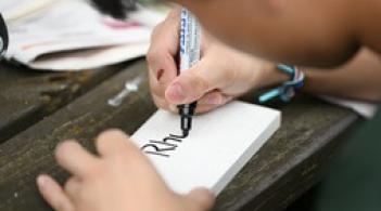 close up of person writing on index card