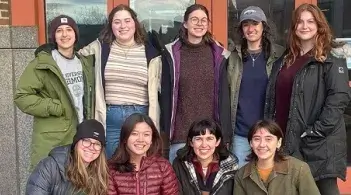 The Femmes in Forestry club posing for a photo outside, five women in the back and four women in the front.