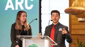 Students give a business presentation at a podium