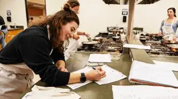 Person taking notes in a kitchen