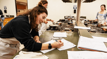 Person taking notes in a kitchen
