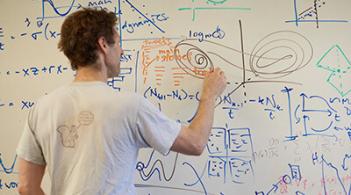 Professor writing on a white board