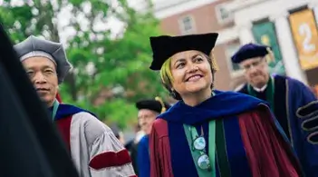 Person smiling in a graduation cap and gown
