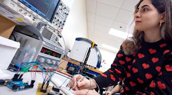 A CEMS graduate student checks electrical connections on a research project
