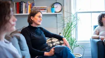 A counselor speaks with students in a group therapy setting
