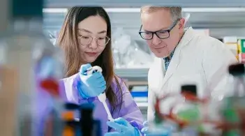 Two researchers examining equipment