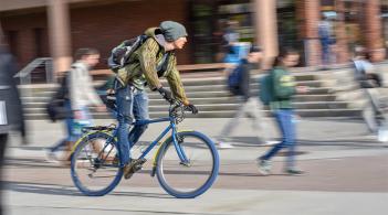 A student travels by bike across UVM's campus