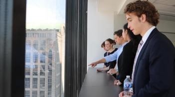 Accounting students look out the window of a Boston high-rise 