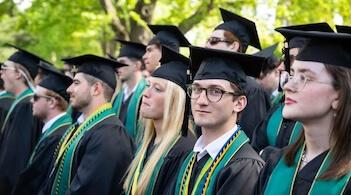 A row of seated graduates wearing regalia